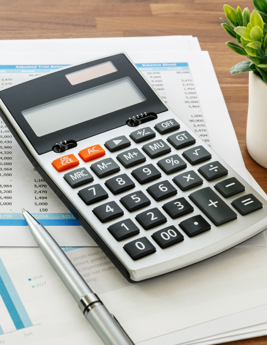 financial calculation with calculator and balance sheet