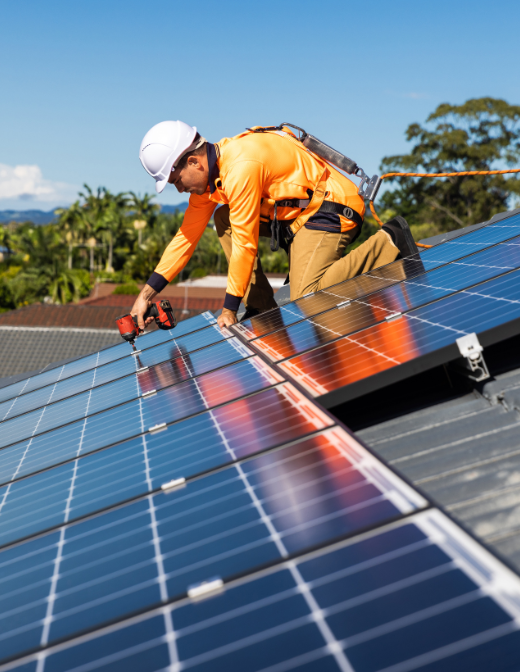 technician installing solar panels on roof